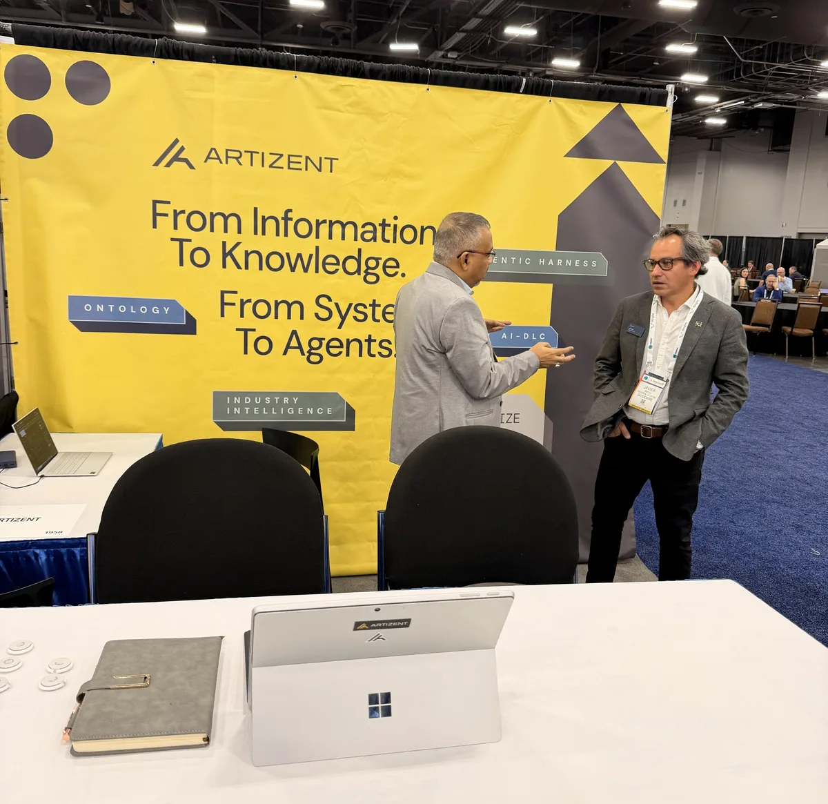Discussion beside the Artizent display at ITC Vegas 2026